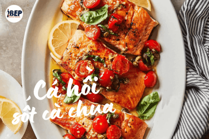 Áp chảo miếng cá hồi vàng nhẹ trên chảo nóng chuẩn bị làm cá hồi sốt cà chua